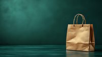 Brown paper shopping bag with rope handles on dark green background with dramatic lighting and copy space for retail and commerce concepts.