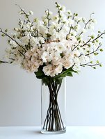 Elegant white orchid stems arranged in tall clear glass vase with water against light background, creating fresh spring floral display for home decor.