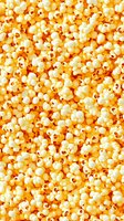 Fresh popcorn background with buttery yellow kernels filling frame, seamless pattern for food industry designs and movie theater marketing materials.