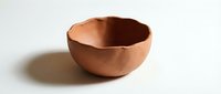 Handcrafted terracotta clay bowl with organic curved edges on white background, perfect for kitchen decor, serving dishes, and artisan pottery projects.