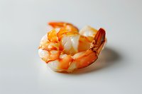 Fresh cooked tiger shrimp on white background, close up view of seafood delicacy with detailed texture and natural orange-pink coloring.