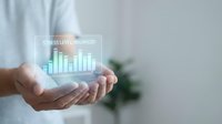 Stress level balanced text with ascending bar chart hologram displayed in cupped hands of person wearing light blue shirt, representing data analysis, mental health monitoring, and wellness metrics.