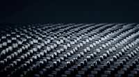 Carbon fiber texture with detailed weave pattern showing high-tech material surface for automotive and aerospace applications.