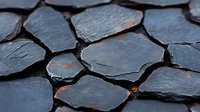 Dark slate stone pieces arranged in mosaic pattern with orange glowing cracks between fragments, creating dramatic natural texture for interior design background.
