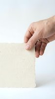 Senior man hand holding blank cream paper card on white background isolated for business presentation and marketing materials.