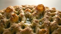 Freshly baked focaccia bread with rosemary herbs and olive oil, golden crust with dimpled surface texture for bakery, food photography, culinary websites.