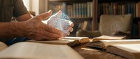 Senior man hands holding glass of water with pills at wooden desk in home library with books and reading glasses for health medication routine.