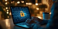 Cybersecurity concept showing glowing padlock on laptop screen with binary code background in dark office setting with bokeh lights and coffee cup.