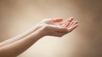 Open cupped hands in gentle receiving gesture against soft beige background symbolizing hope, prayer, support and spiritual connection for wellness concepts.