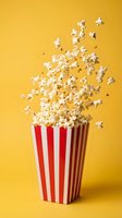 Popcorn exploding from red striped container on bright yellow background for cinema entertainment and movie theater snack advertising concepts.