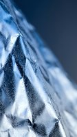 Macro close-up of frost-covered leaf surface with crystalline ice formations and geometric patterns in cool blue tones, suitable for winter and nature backgrounds.