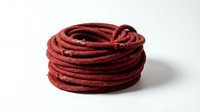 Coiled red rope or cord made from natural fiber material, isolated on white background for commercial, industrial, or craft projects.