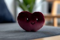 Burgundy plush heart with cute smiling face on gray textile surface, soft focus background creates dreamy atmosphere for valentines and love concepts.