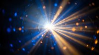 Bright starburst light rays radiating from central point with blue and orange bokeh particles creating dramatic lens flare effect on dark background.
