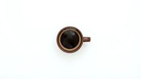 Brown ceramic coffee cup with black coffee viewed from above on white background isolated for design projects and commercial use.