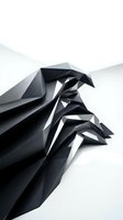 Abstract black geometric sculpture with sharp angular facets and dramatic shadows on white background for modern design projects.