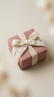 Elegant pink gift box with cream satin ribbon bow on neutral background for special occasions and celebrations.