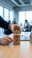 Businessman stacking wooden blocks with business icons in modern office environment, representing strategy, growth, and teamwork for corporate success.