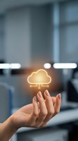 Hand holding glowing cloud computing icon in modern office environment representing digital transformation and data storage solutions.