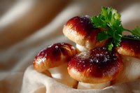 Fresh baked sweet buns with berry jam glaze and parsley garnish on light fabric background, macro food photography with soft natural lighting.