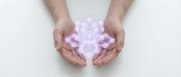 Hands gently protecting glowing pink crystal brain symbolizing mental health care, mindfulness and neurological wellness on white background.