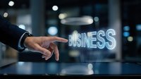 Professional businessman hand pointing at glowing BUSINESS text hologram in modern office environment with bokeh lights background for corporate presentations.