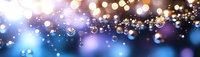 Glowing golden bokeh lights on blurred blue and purple background creating festive atmosphere for celebrations and special events.