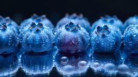 Fresh ripe blueberries with water drops in macro photography showing detailed texture and natural moisture on dark background, creating appetizing look.