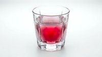 Glass of red juice or cranberry drink isolated on white background, suitable for beverage, food and drink, and health-related design projects.
