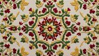 Ornate floral embroidery pattern with red flowers and golden leaves on cream fabric background. Traditional decorative textile design for upholstery projects.