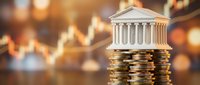 Classical bank building model on stacked coins representing financial stability, investment growth, and economic prosperity in warm golden light.