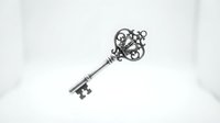 Ornate vintage silver key with decorative scrollwork head isolated on white background for antique design projects and security concepts.