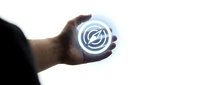 Hand holding glowing circular technology symbol with interconnected rings representing digital innovation and futuristic connectivity concepts.