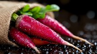 Fresh red radishes with water drops in burlap sack on dark background, macro shot showing vibrant color and texture, raw organic produce for healthy eating.