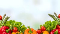 Fresh organic vegetables border with lettuce, tomatoes, peppers and asparagus on white background for healthy cooking and nutrition concepts.