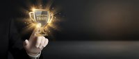 Businessman in dark suit pointing at glowing award trophy with golden light rays, symbolizing success, achievement, and recognition in corporate environment.