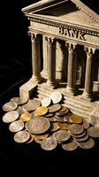 Miniature stone bank building model surrounded by scattered gold and silver coins on dark background, symbolizing finance, savings, and wealth.