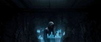 Man in dark hoodie analyzing glowing blue data charts and financial graphs in a dimly lit environment, suitable for technology, cybersecurity, and business analytics concepts.