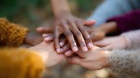Gentle caring hands holding each other in support and comfort, expressing unity, empathy and emotional connection against soft blurred background.
