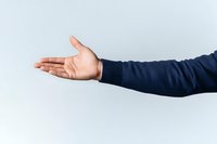Male African American arm extended wearing navy blue sweater showing open palm gesture against light background, welcoming presentation pose.