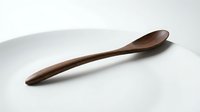 Handcrafted wooden spoon with smooth curved handle and bowl shape, natural wood grain texture, kitchen utensil for cooking and serving on white background.