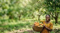 Young African woman farmer holding wicker basket filled with fresh harvested vegetables and fruits in lush green orchard garden setting for agriculture and farming concepts.