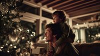 Young father and toddler son enjoying magical Christmas morning together by illuminated tree in cozy living room with warm lighting and festive decorations.