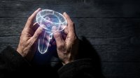 Elderly hands protecting glowing holographic brain with neural networks, representing mental health awareness, dementia prevention and cognitive care.