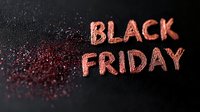 Pink glittery text spelling Black Friday on dark background with scattered sparkles and glitter creating festive holiday shopping season atmosphere.