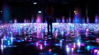 Young woman silhouetted against glowing interactive light installation with blue and pink illuminated floor panels creating immersive digital art experience in dark space.