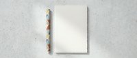 Blank white canvas or paper sheet with colorful geometric triangle border on textured concrete wall background for creative design projects.