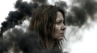 Exhausted woman with disheveled hair against dramatic stormy sky with dark clouds. Emotional portrait showing fatigue, stress and resilience after hardship.