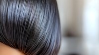 Close up view of dark straight glossy hair with smooth texture and natural shine against blurred background, showcasing healthy haircare and beauty treatment results.