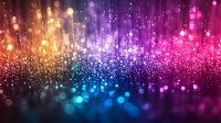 Vibrant multicolored bokeh lights with glowing particles creating magical atmosphere on dark background, abstract defocused sparkles in blue, purple and pink tones.